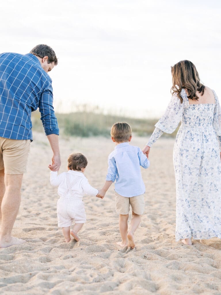 Family of four walking together at the beach 