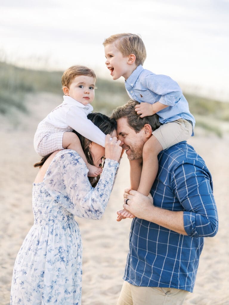 Mom and dad with boys on their shoulders at the beach 