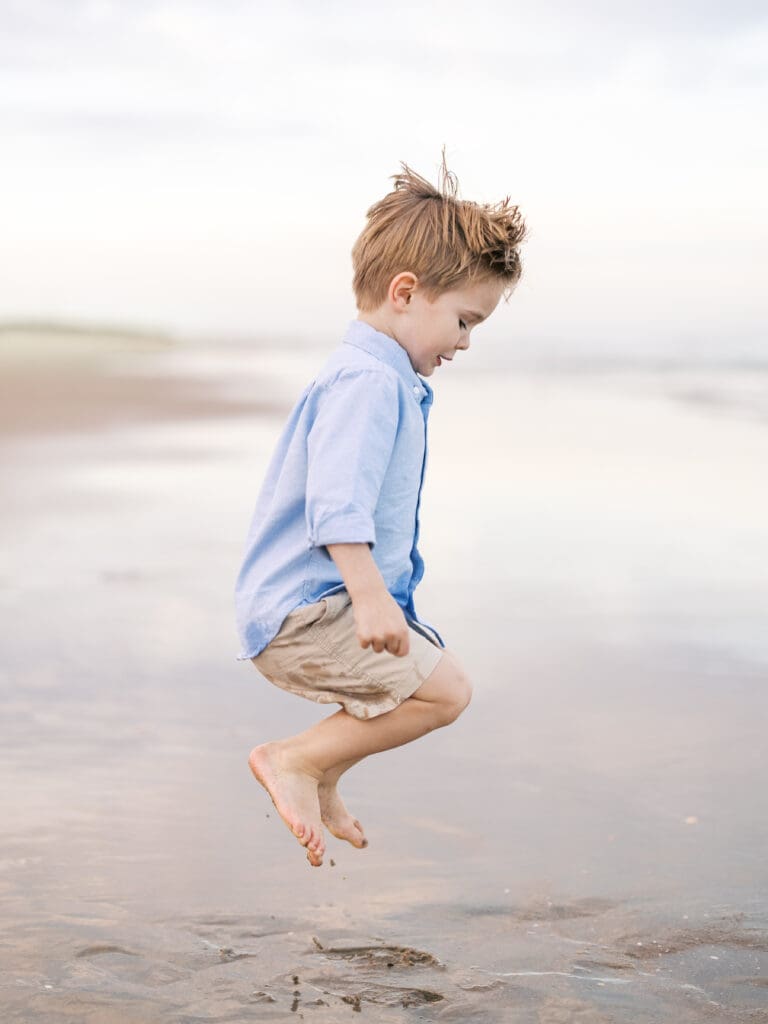 Boy jumping at the ocean at the beach 