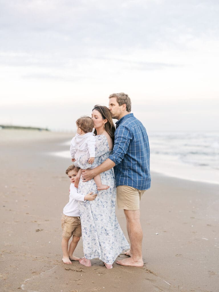 Mom and dad and their two boys at the ocean 