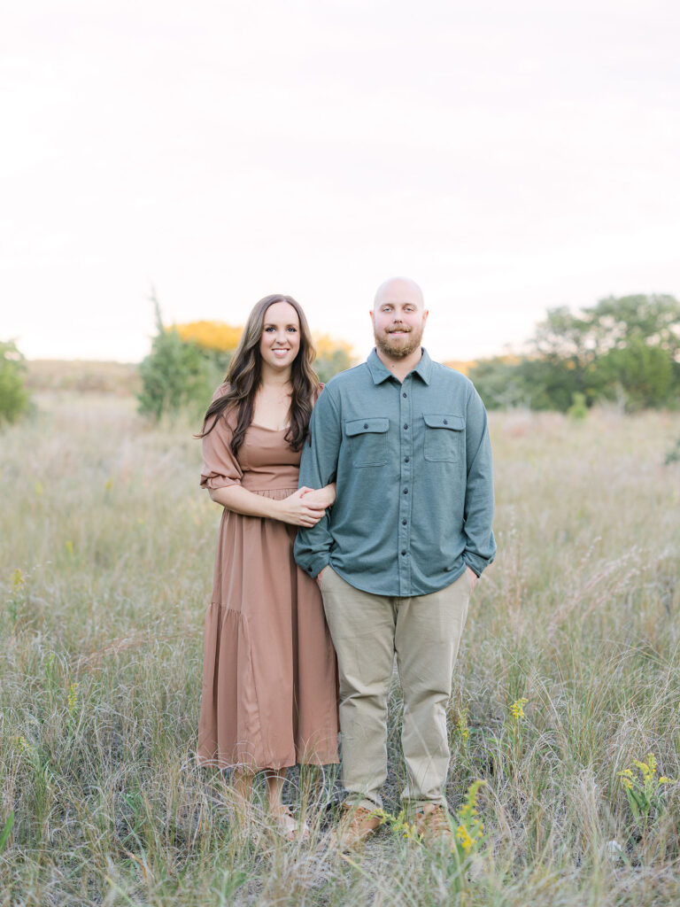 Woman in tan dress and man in green shirt and khakis posing in field for Hampton Roads Family Photographer Ashley Brickner 