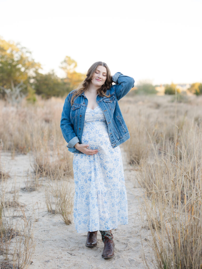 Pregnant mom wearing blue maxi dress standing in field by Virginia Beach maternity portraits photographer Ashley Brickner 
