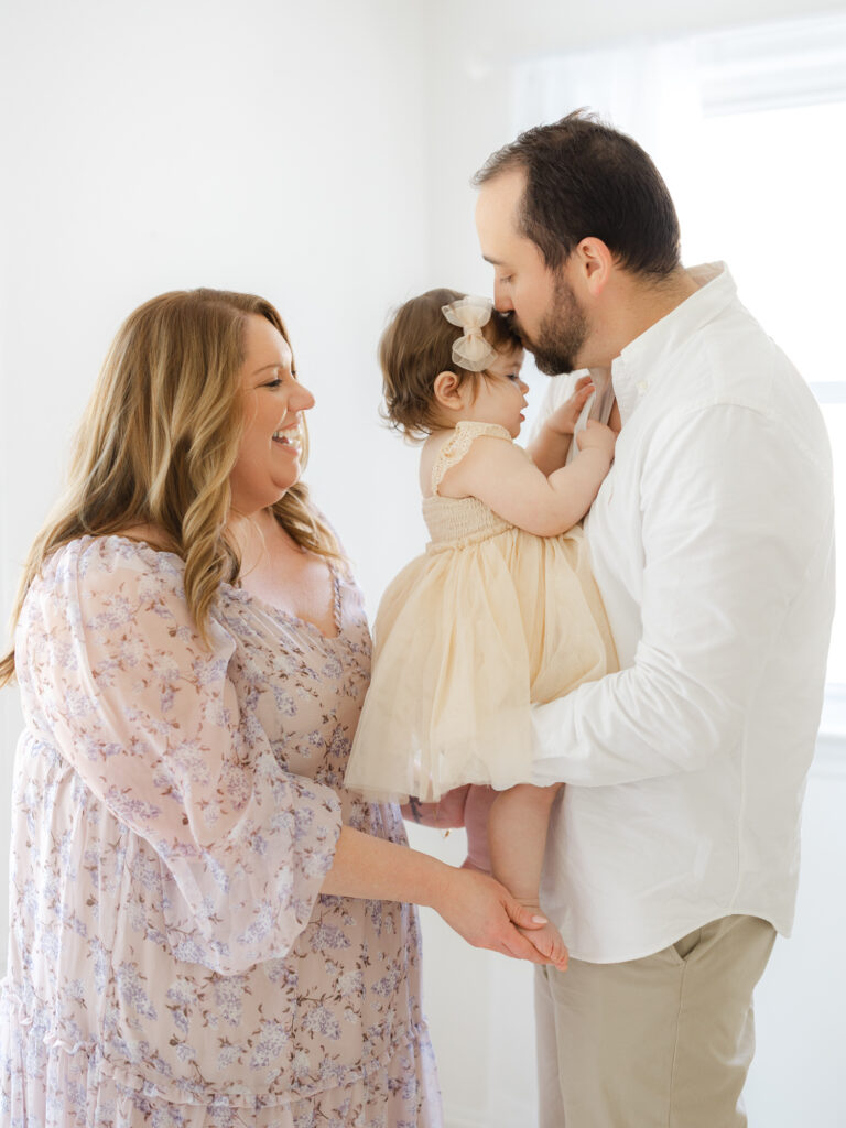 Family of three standing closely in Hampton Roads studio
