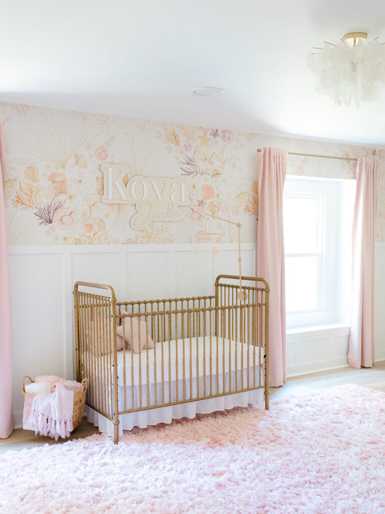 Pink and floral nursery with brass crib and pink rug photographed for an in-home lifestyle newborn session by Ashley Brickner 