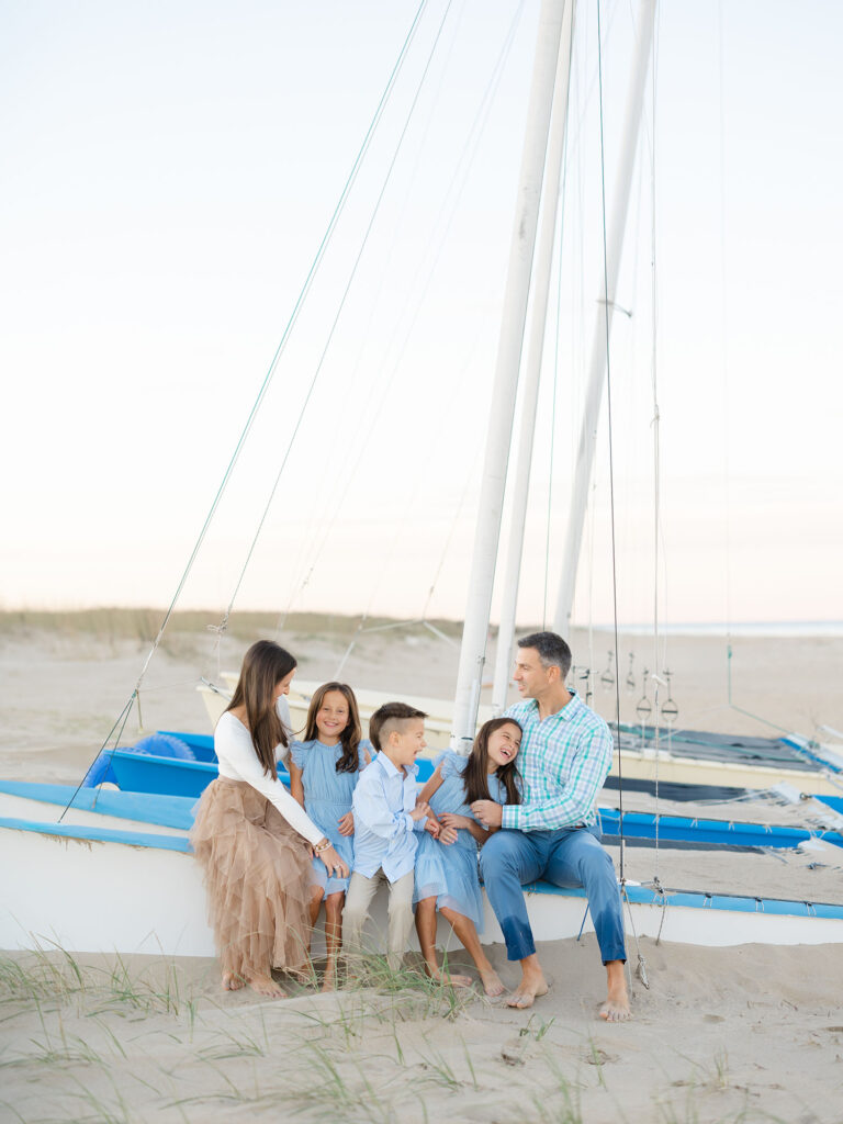 Family of five sitting on boat laughing during Virginia Beach Mini Session by Ashley Brickner 