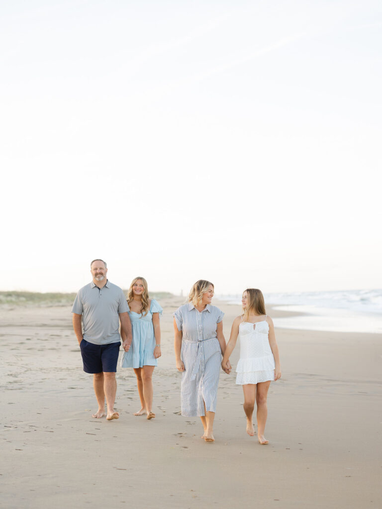 Family of four walking on beach in blue tones during Virginia Beach Mini Session by Ashley Brickner 