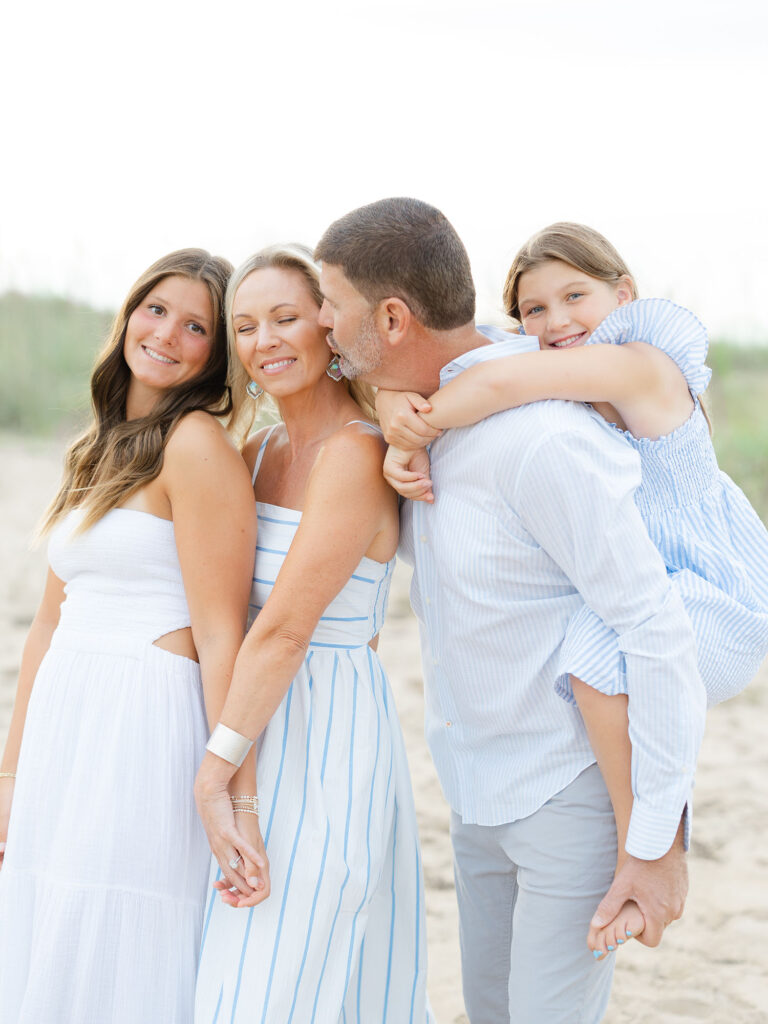 Family of four in blue and white on north end beach 