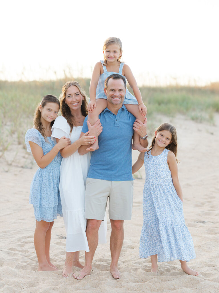 Family of five dressed in blue and neutrals on the beach taken by Virginia family photographer Ashley Brickner 