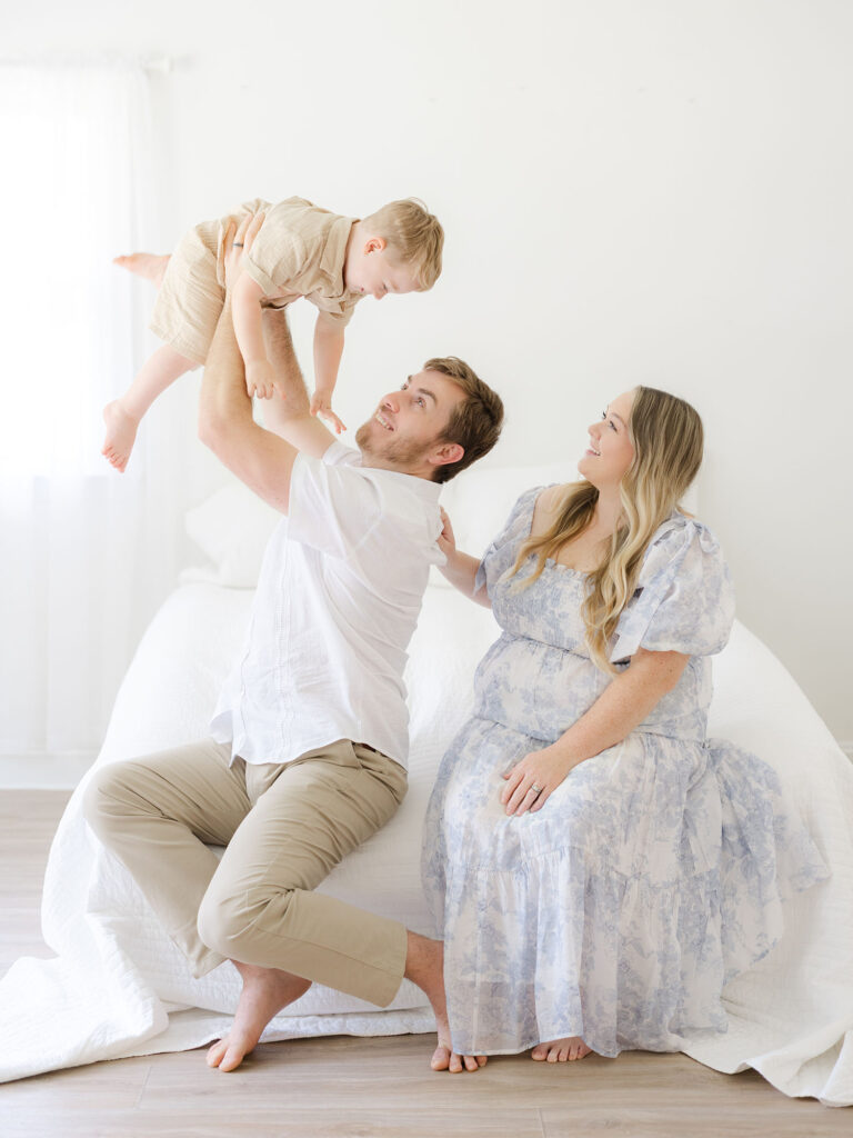 Family of three dressed in blues and neutrals in Virginia Beach studio 