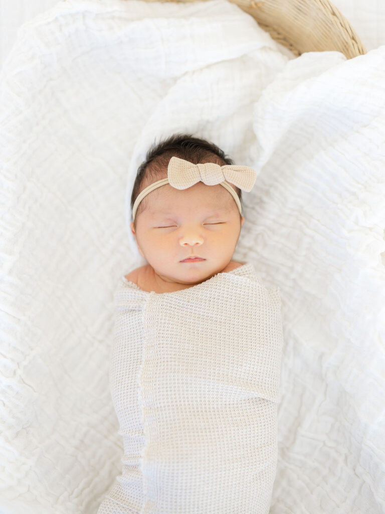 Swaddled newborn baby girl laying in basket by Virginia newborn photographer Ashley Brickner 