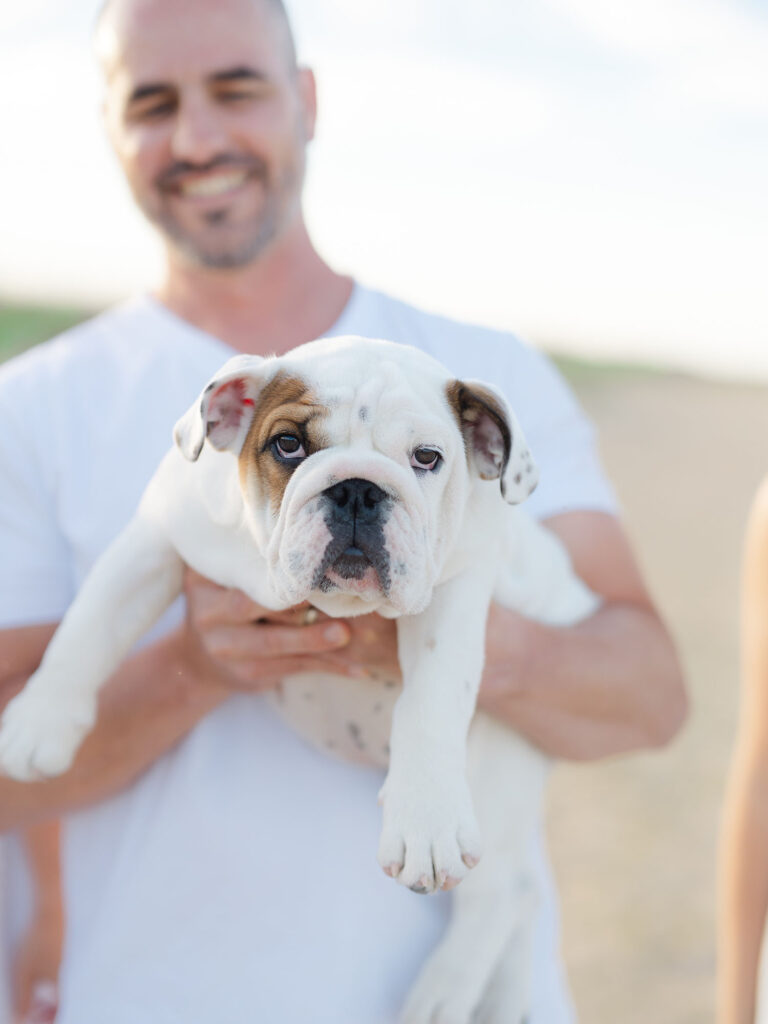 Man holding dog on beach in family photo with dog by Virginia Beach family photographer Ashley Brickner 