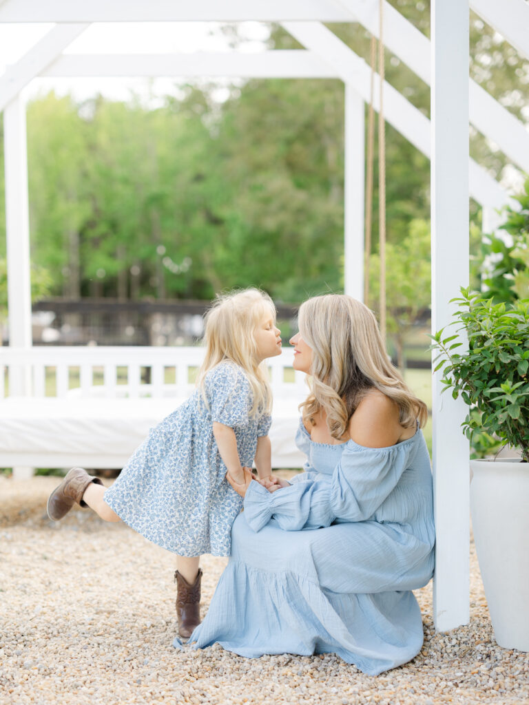 Mom in blue dress kneeling down with daughter in blue floral dress for Virginia Beach summer photos by Ashley Brickner  