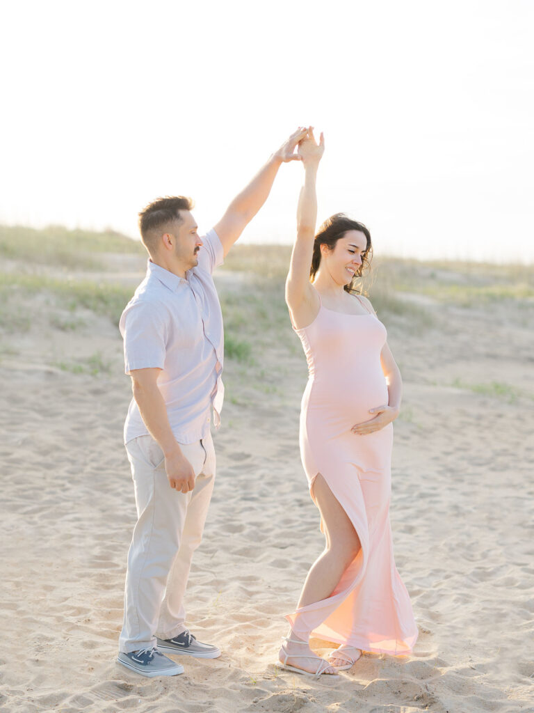 Man and woman on beach for maternity photos by Ashley Brickner 